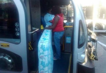 woman bringing matress on bus